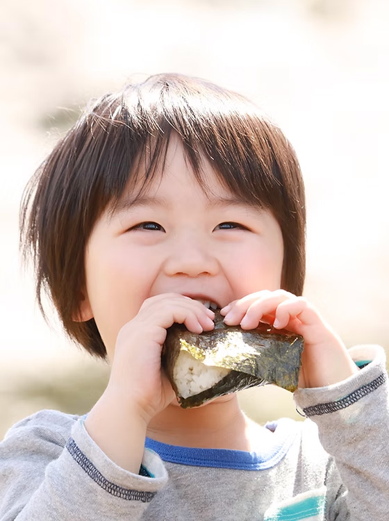 おにぎりを頬張る男の子